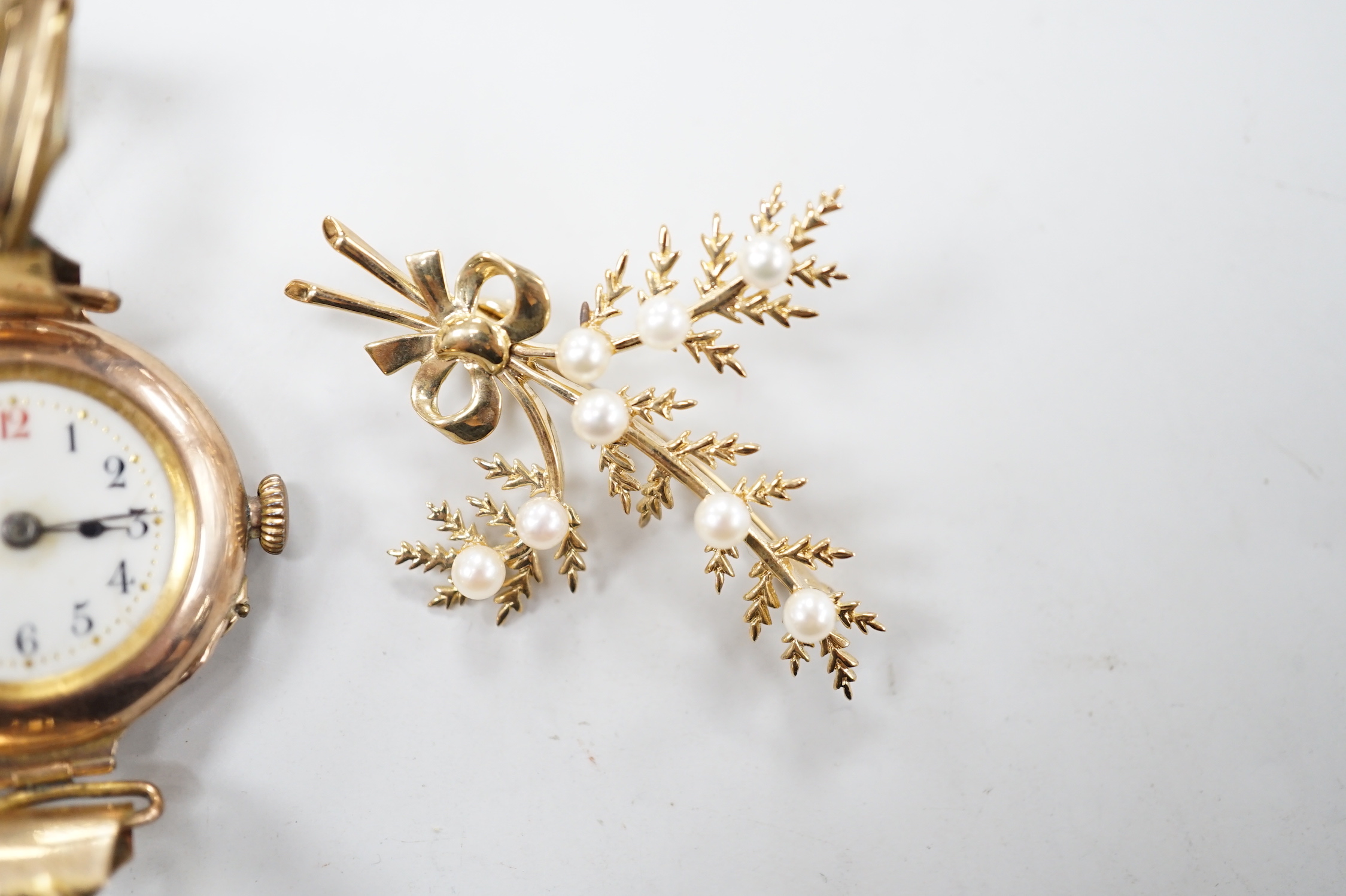 A lady's early 20th century 9ct gold, manual wind wrist watch, on a gold plated strap, together with a modern 9ct gold and seed pearl floral spray brooch.